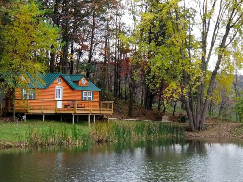 cute orange cabin sitting on lake