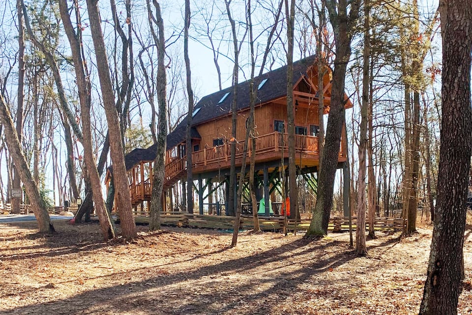 Tree house cabin in Virginia with wooden railing and surrounded by trees