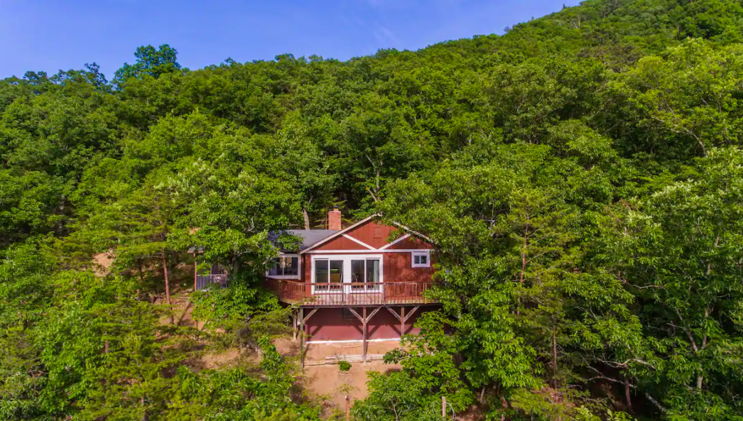 red cabin nestled in the trees Airbnbs in Virginia