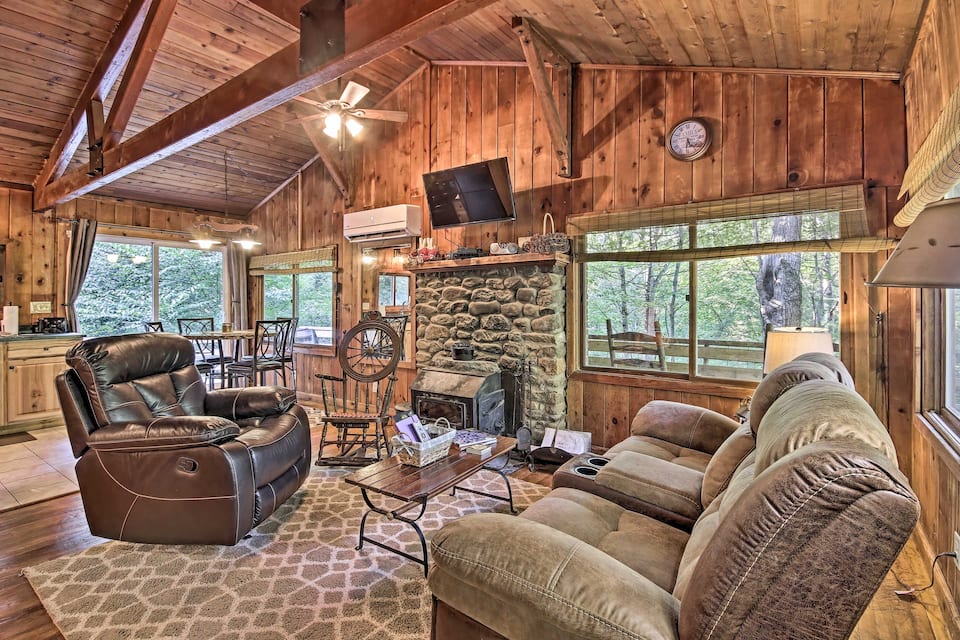 Luxury cabin rental in Virginia do not come much better than this one: high-quality wood throughout living room with over-sized recliners and large windows to see nature outside.