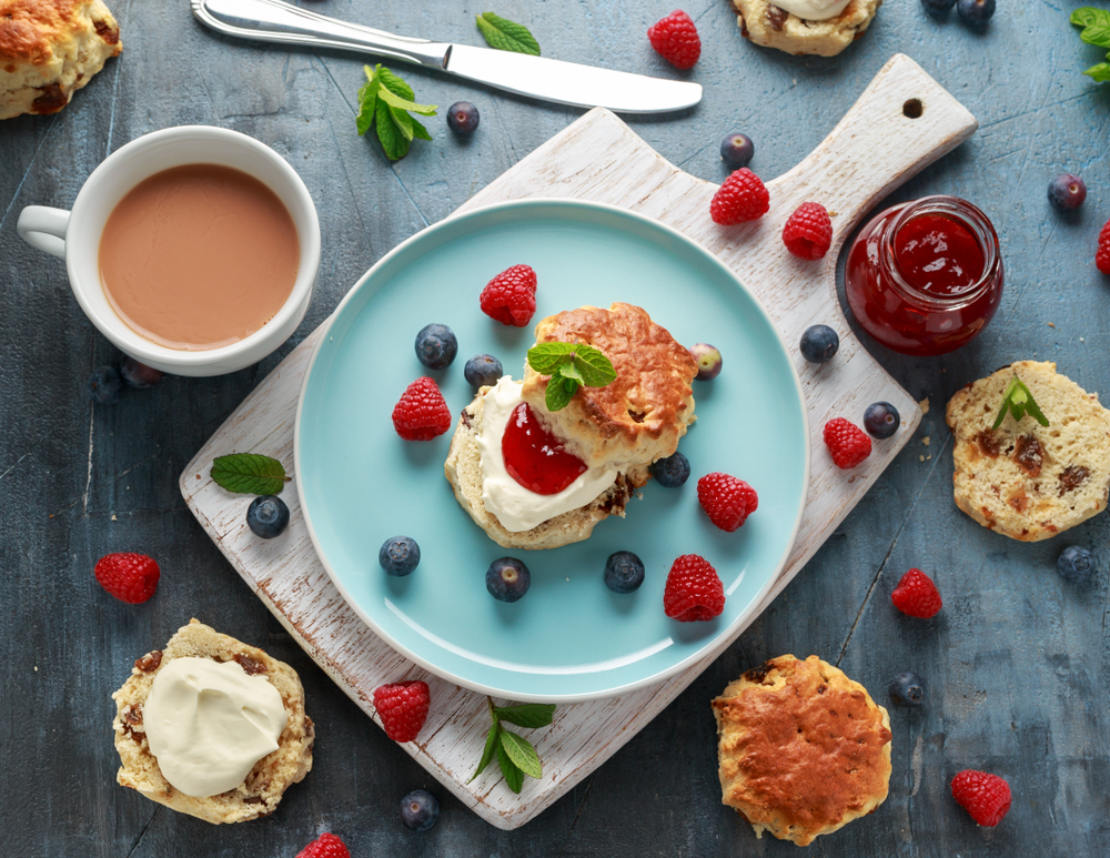 classic scones with cream and jam served on a blue plate