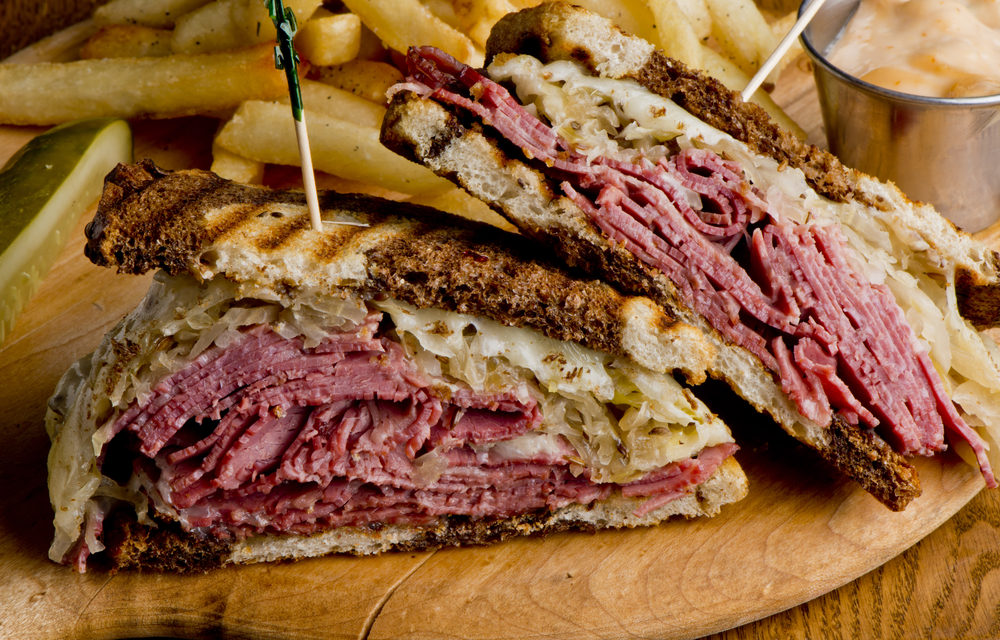 pastrami and corned beef sandwich on a wooden board