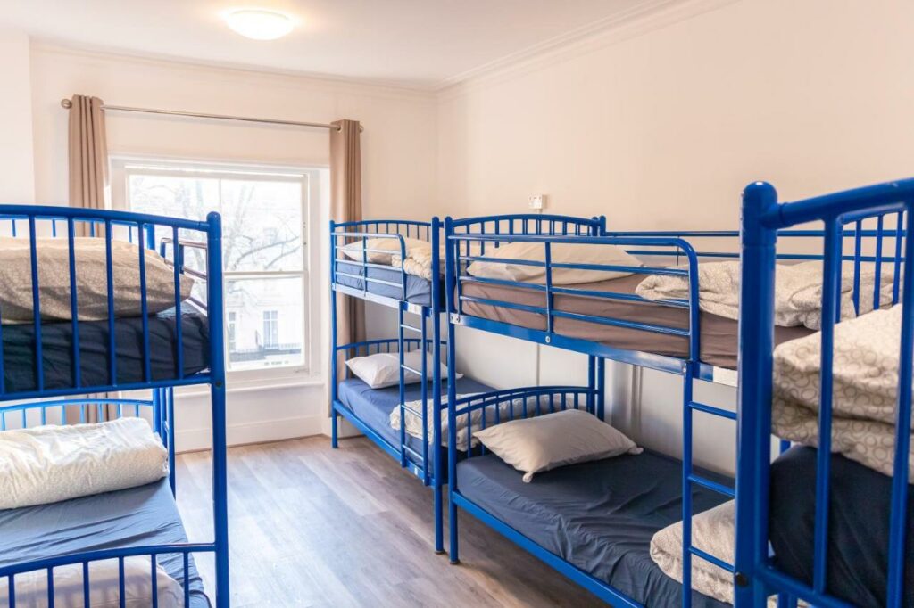 white walled dorm room with multiple bunk beds
