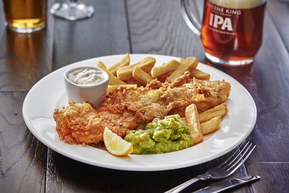plate containing fish and chips with a pint of beer restaurants in chelsea london