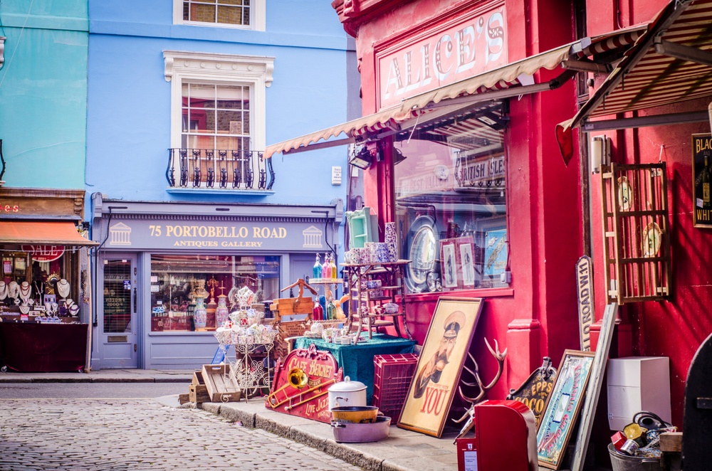 Colourful buildings and antique shops on London's Portobello Road, a famous shopping street and popular tourist attraction. The article is about the best walks in London. 