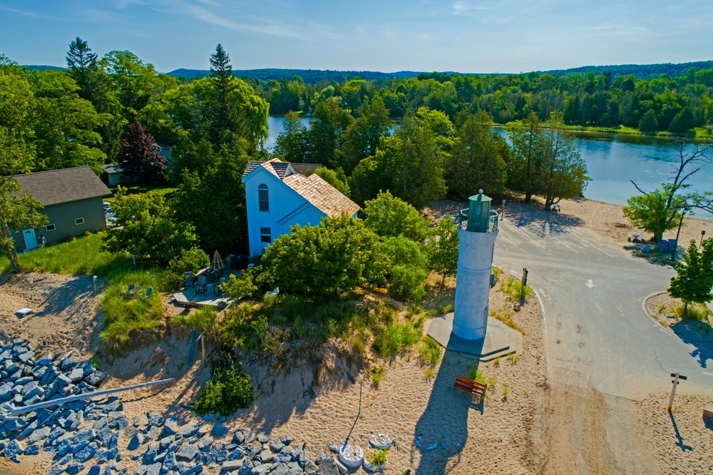 aerial view of a lighthouse surrounded by trees and buildings
