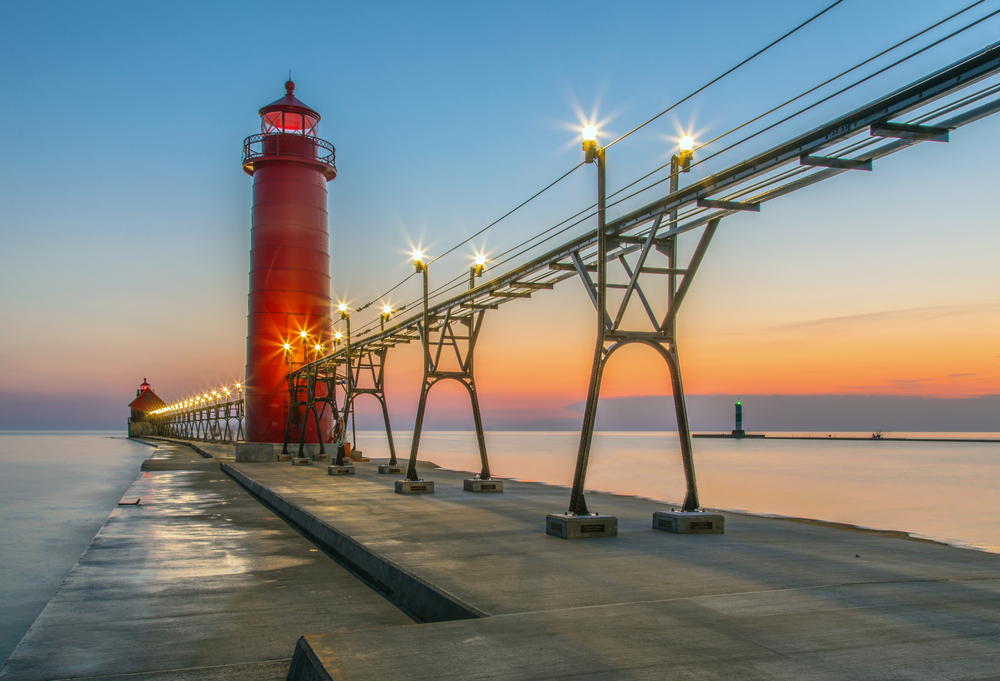 view of lighthouse during sunset on a pier