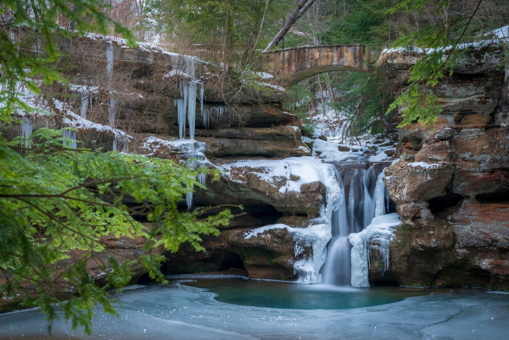 Beautiful Upper Falls in Hocking Hills State Park covered in snow and ice during winter.