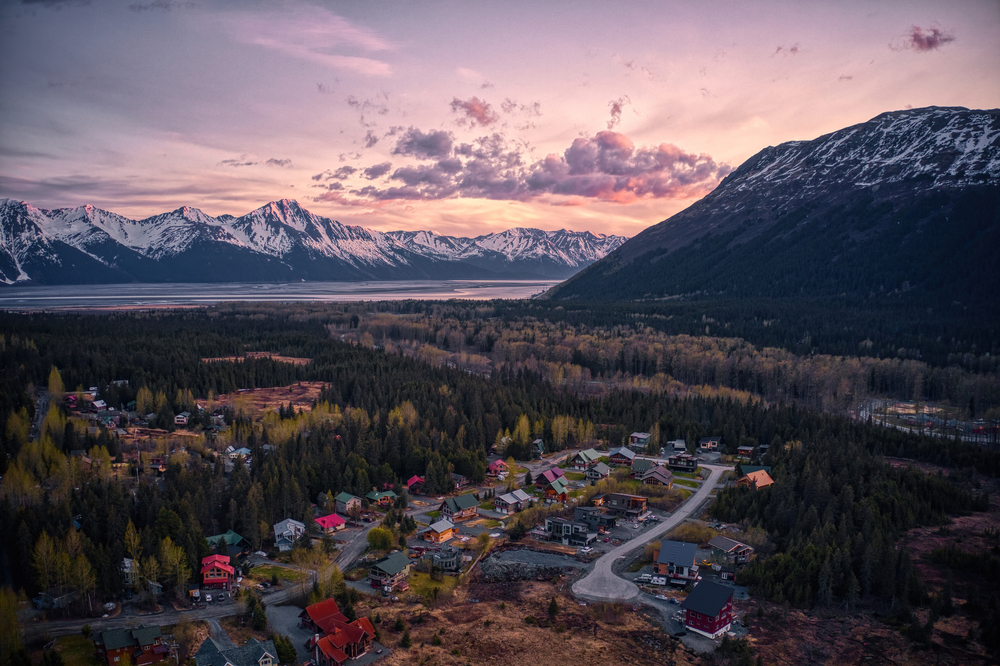aerial view of a town surrounded by forest and mountains towns in alaska