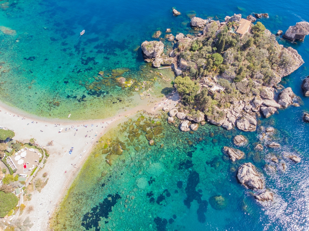 aerial view of a beach surrounded by clear water things to do in taormina