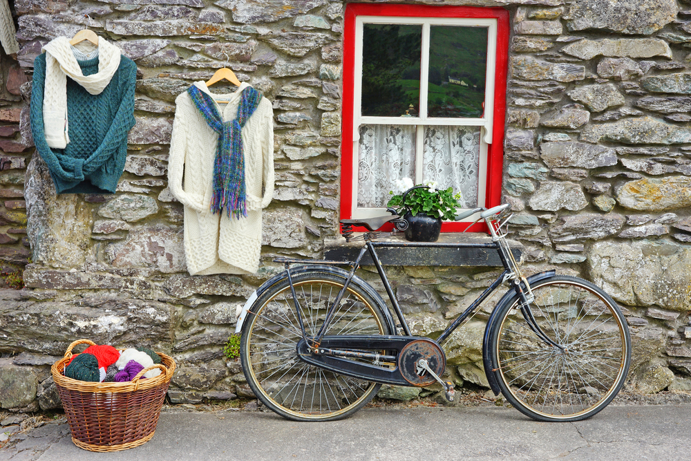 woolen clothing and a rustic bike beside a stone brick wall traveling to ireland