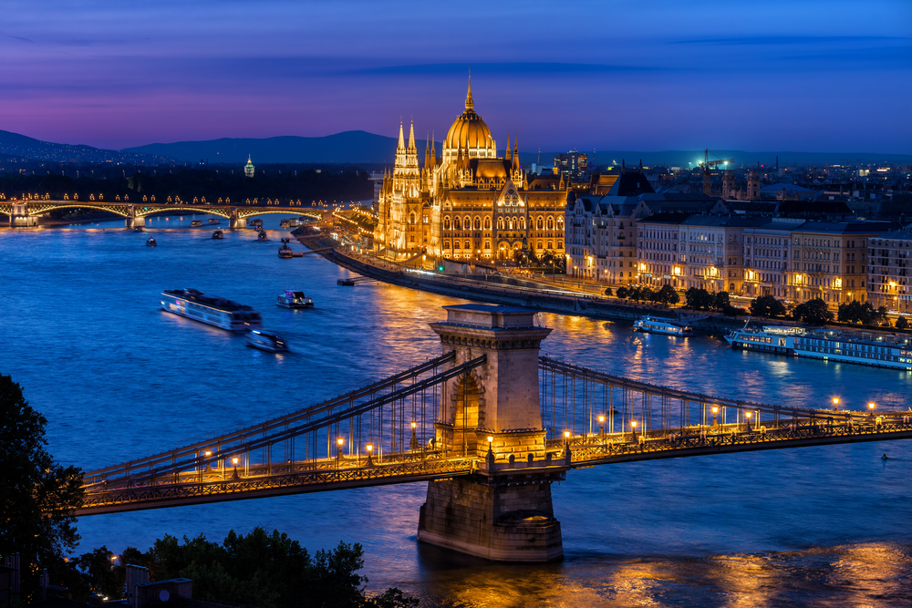 illuminated city beside a river at blue hour traveling to budapest