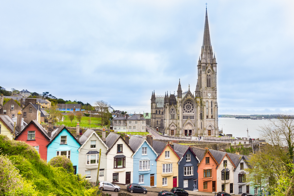 colored houses and cathedral beside a river traveling to ireland