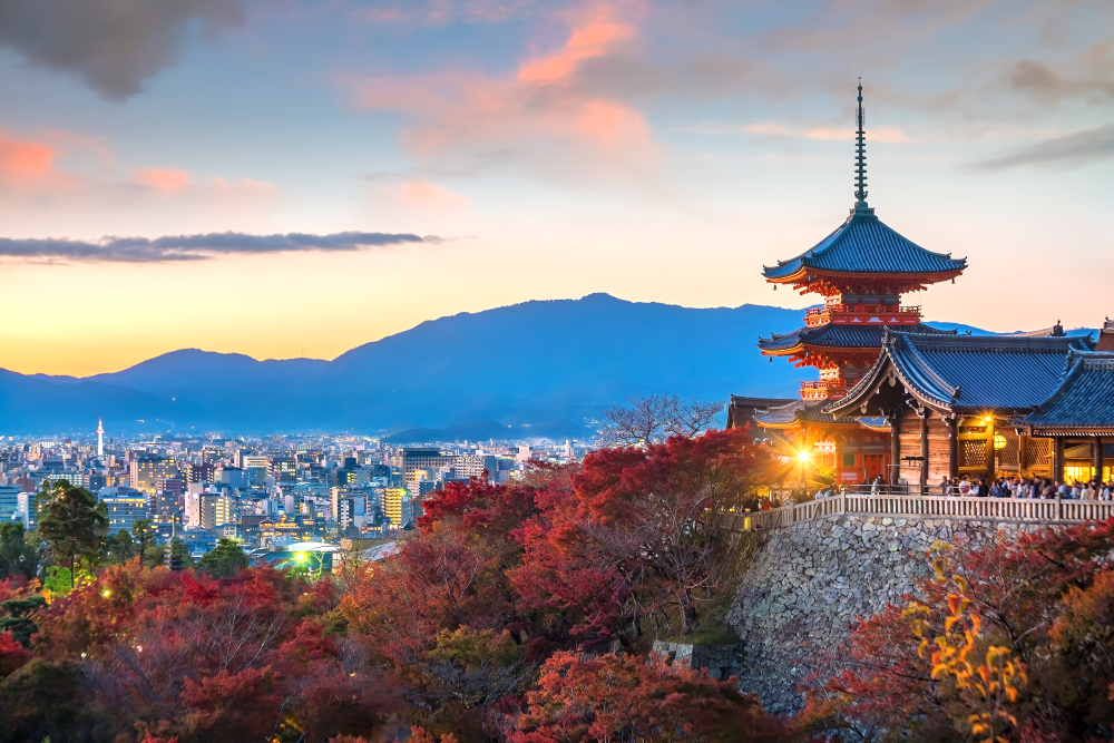 temple on a cliff overlooking the city with mountains in the background like you will view when traveling to Japan for the first time.