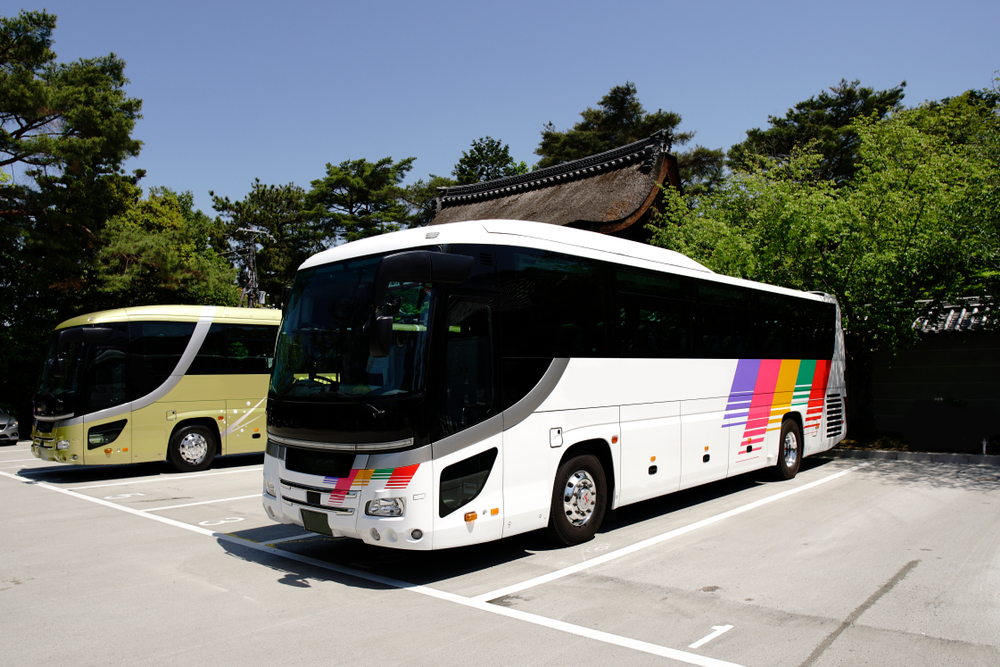 big bus with white coating and few colorful stripes