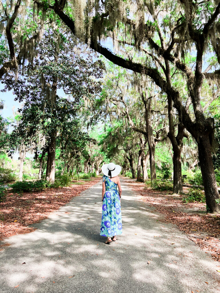 woman walking on a path with trees on both sides