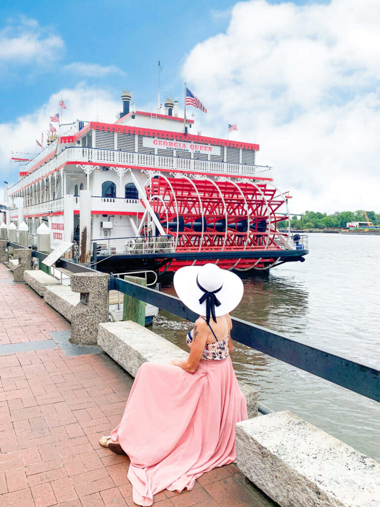 women sitting on a bench overlooking the boat in the river best things to do in savannah