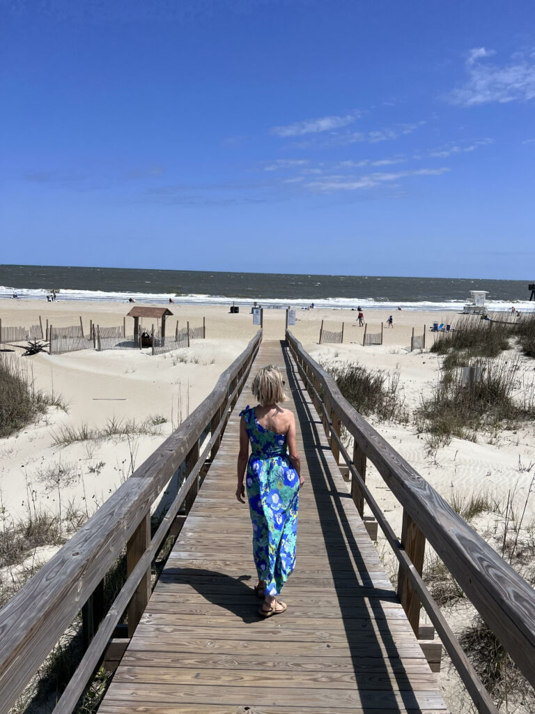 women walking on a wooden pathway to the beach best things to do in savannah