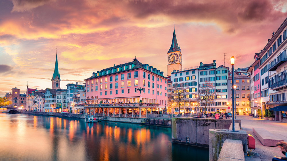 evening sky in a city with colorful buildings beside a river romantic cities in europe