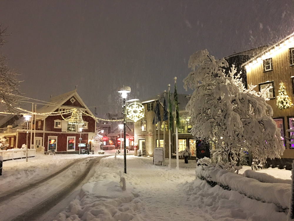 snowing in a town with christmas lighting christmas vacation ideas