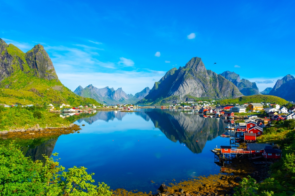 mountain village with colorful houses with a lake in the middle and mountains in the background