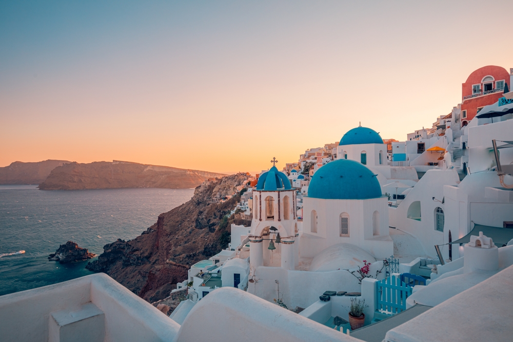 white houses with blue color dome on cliffs summer in europe