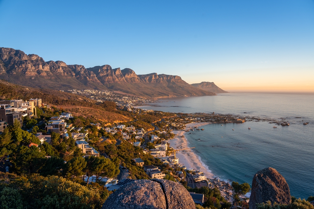 view of a coastal town with rocky mountains from a cliff