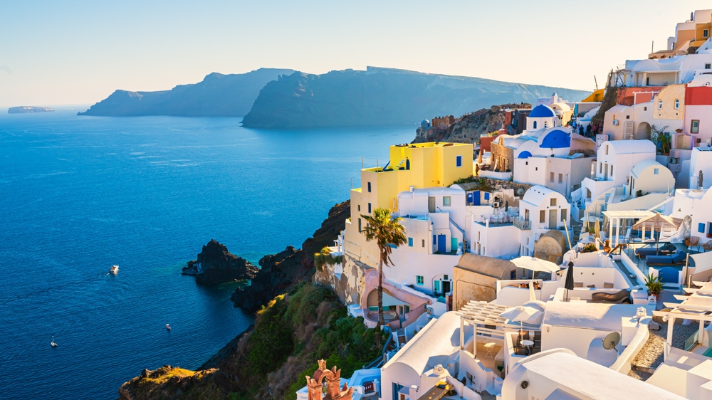 white buildings with blue dome on a cliff beside the ocean Best Spring Break Destinations for Families