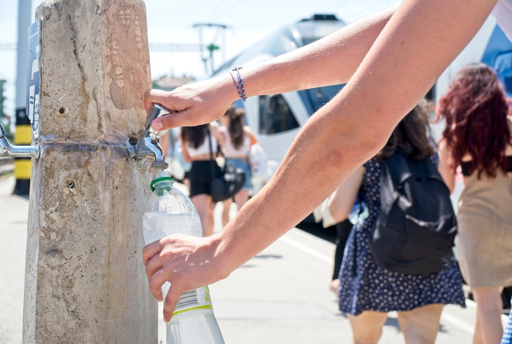 person refilling his water bottle from tap europe vacation tips