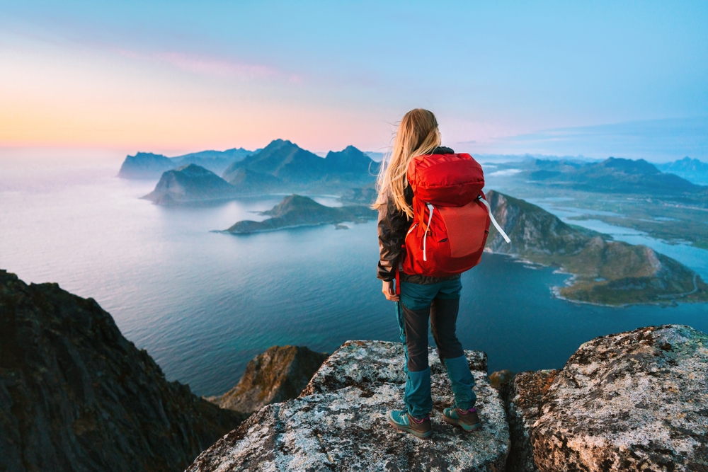 girl with red daypack enjoying view of the islands with mountains europe vacation tips