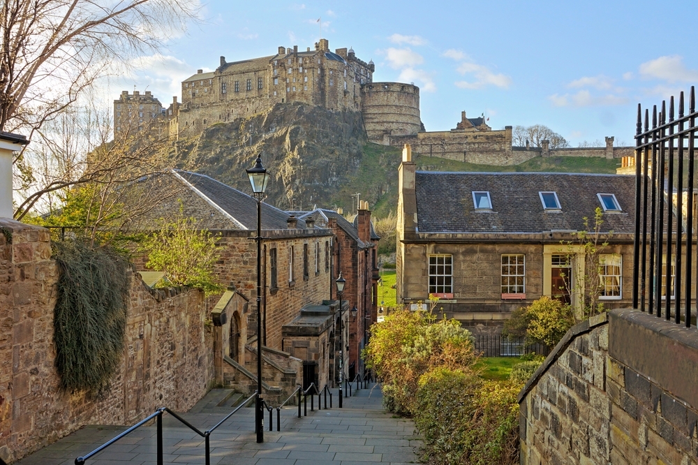 view of a castle on the hill top with buildings at the base