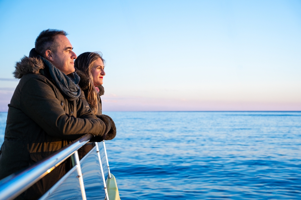 a middle aged couple in coats on the cruise boat