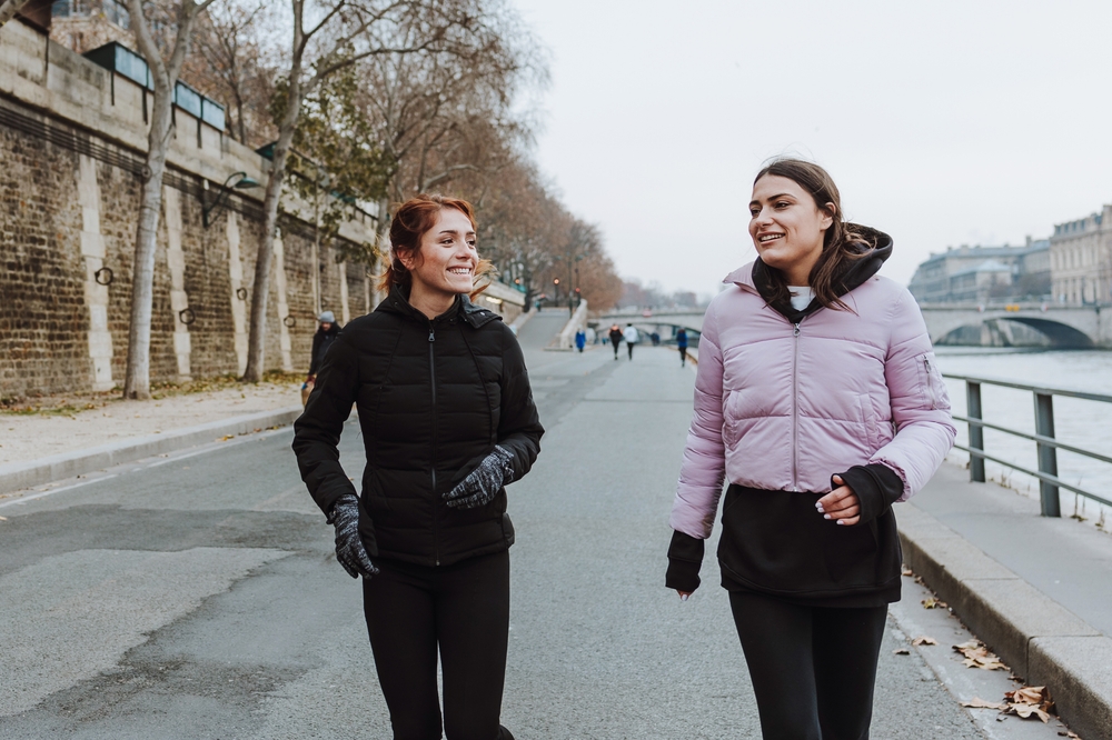 two girls walking on the road wearing jackets paris in winter