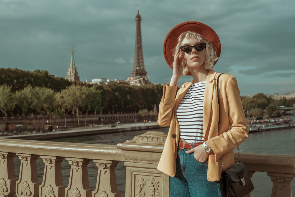 woman wearing checked top with blue jeans and yellow light jacket