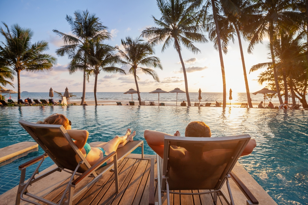 couple chilling beside a pool with ocean views traveling to the maldives