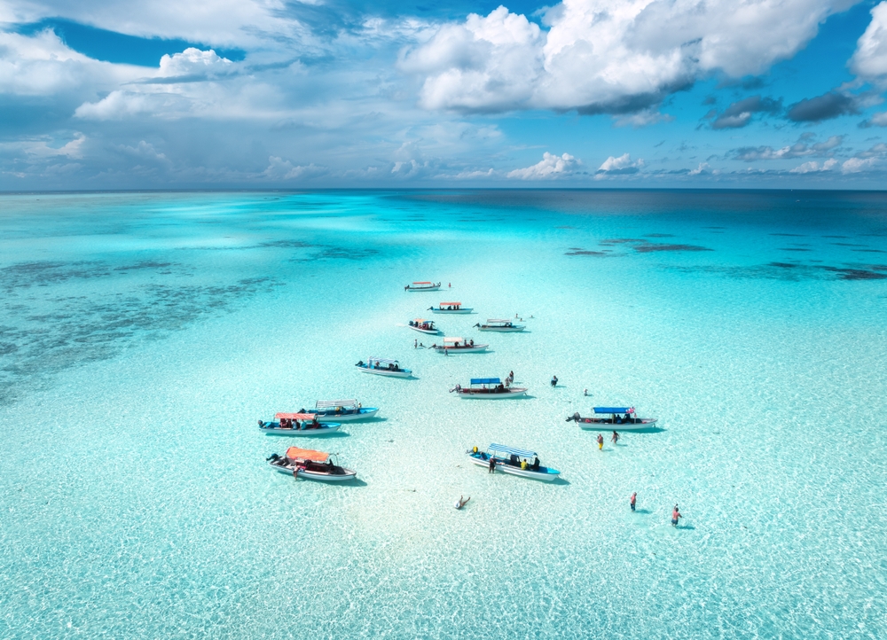 aerial view of colorful boats in the clear ocean