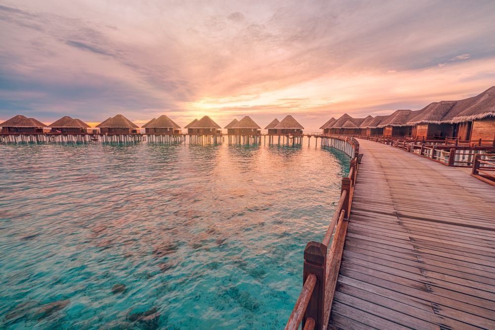 water villas togethether during a sunset traveling to the maldives