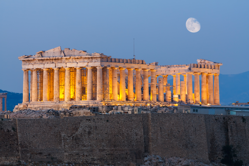 closeup of a monument with columns with the moon in the sky things to do in athens