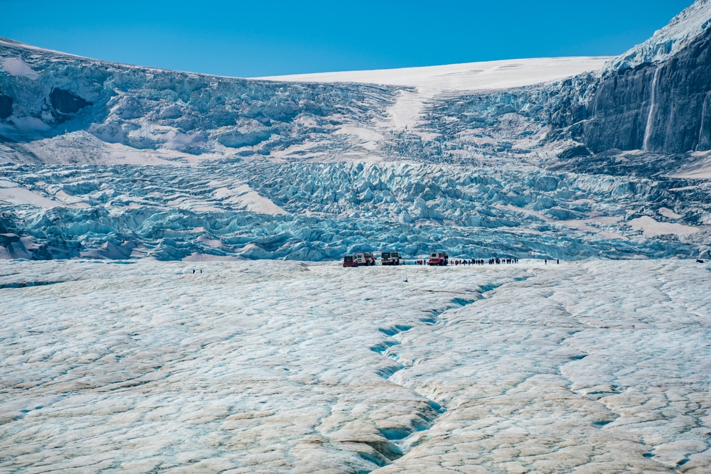 people walking on huge glacier