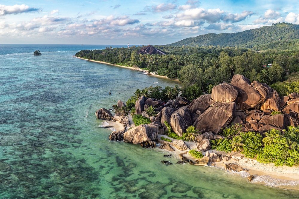 aerial view of a beach with lots of trees and unique rocks warm weather getaways