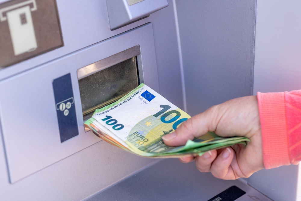woman taking out euro from ATM traveling to italy