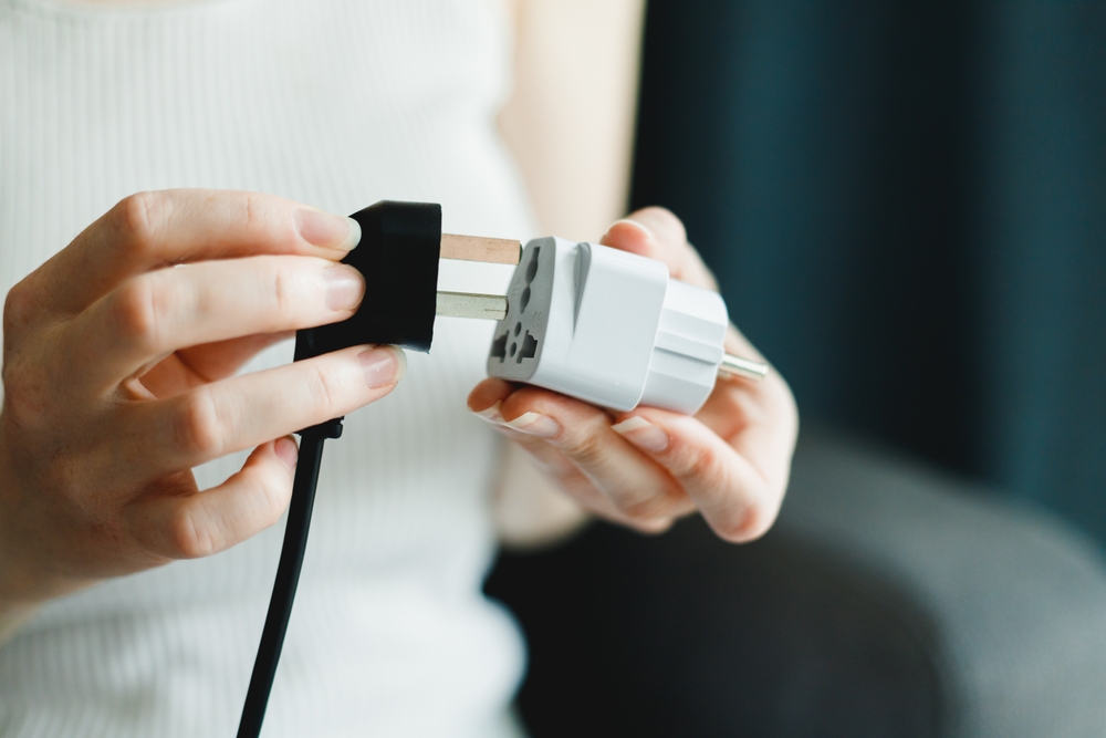 woman uses universal travel adapter