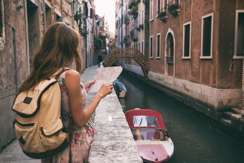 travel girl looking at a map of walking traveling to italy