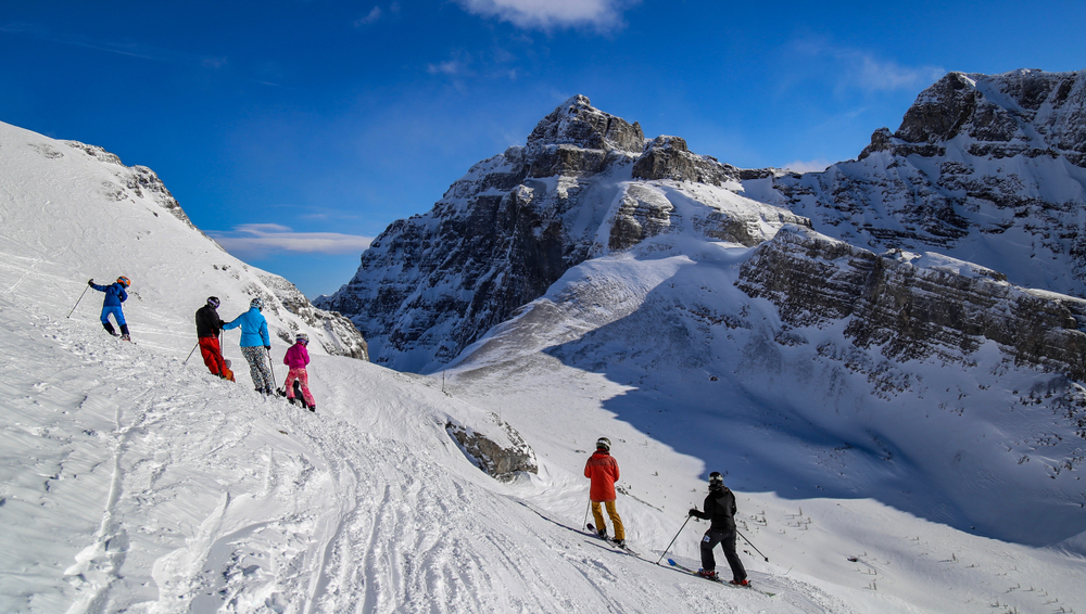 family skiing on snowy mountain