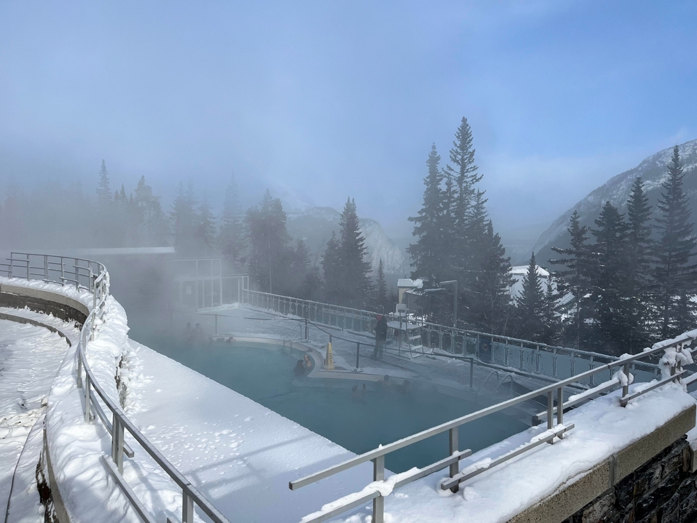 steam rising from hot water on a rooftop with views of mountains