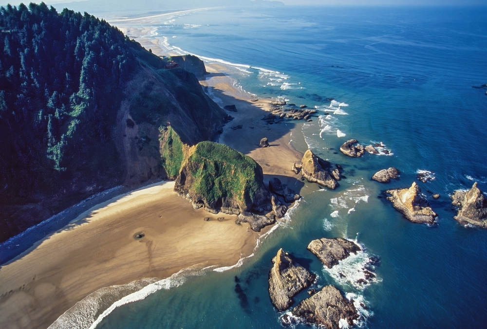 aerial view of a coastal beach with cliffs and rocks