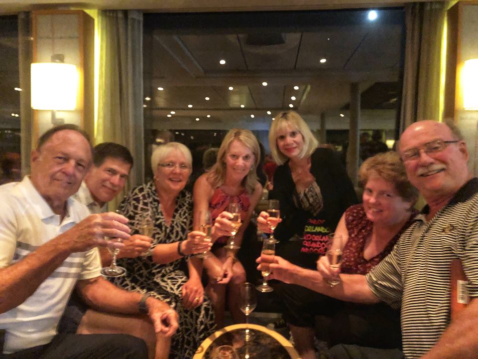 Group of men and women toasting with champagne glasses.