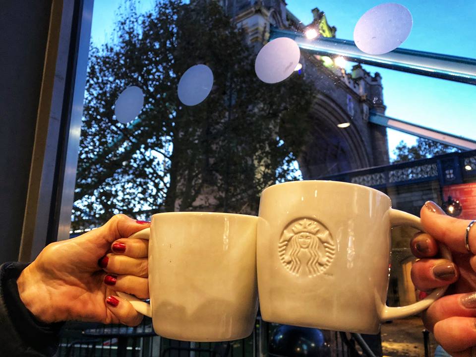 First time in London toasting with Starbucks coffee mugs. Tower bridge is in the background. 