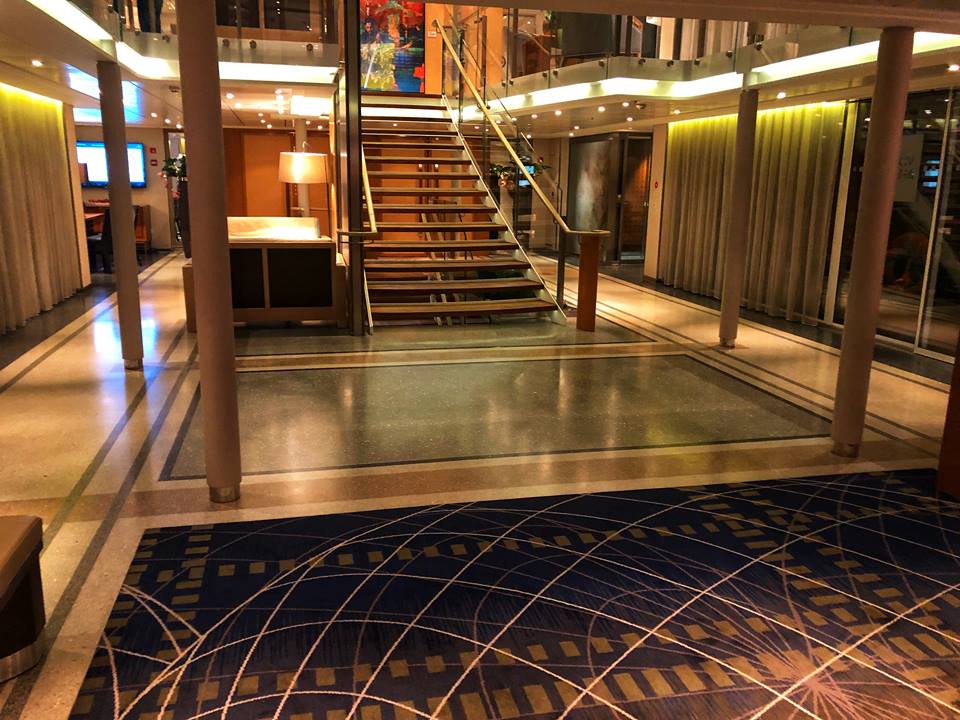  lobby with staircase in the middle and marble floors.