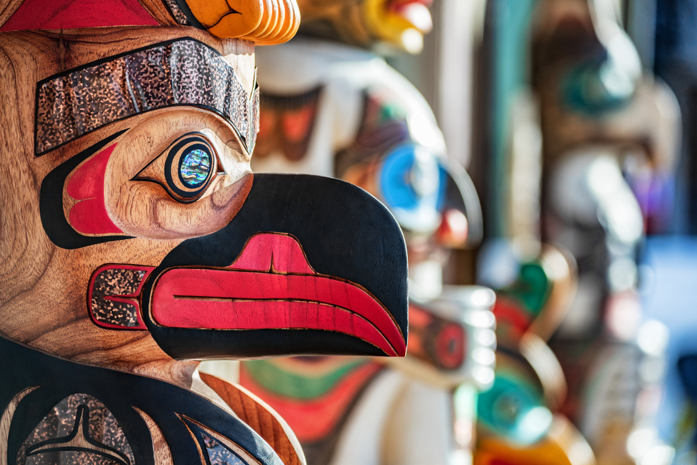 colorful wooden totem pole with face of animal with beak. 